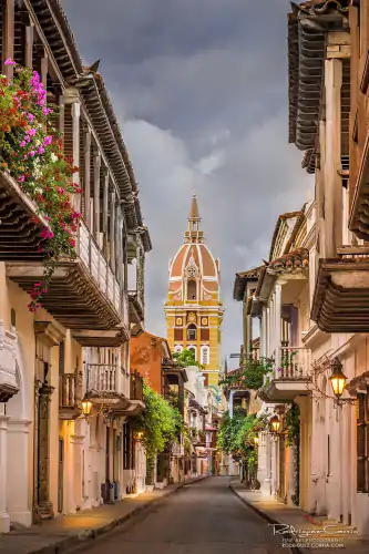 Early morning street view of Cartagena, Colombia with lit colonial street lamps with the cathedral in the background.