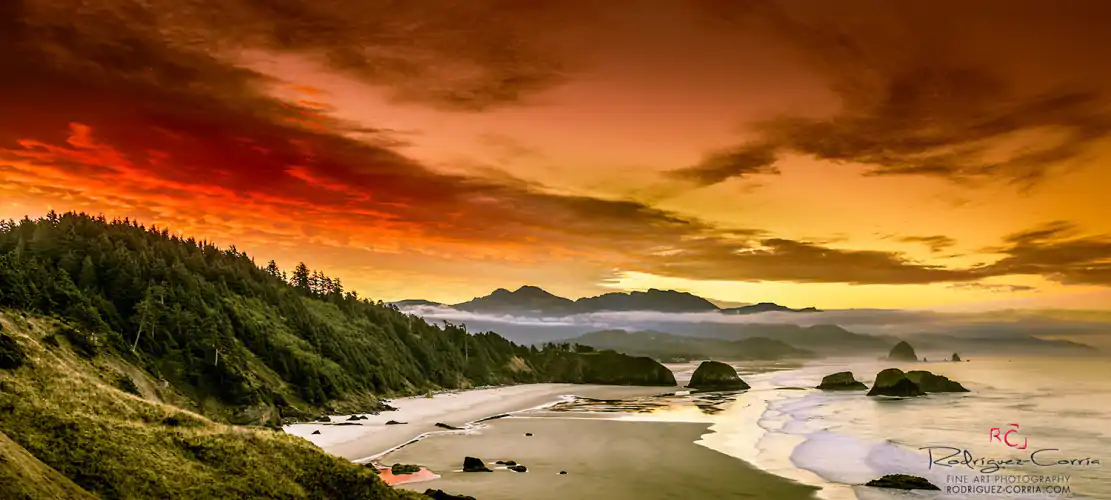 Oregon coast scene with a red sunrise and Canon Beach in the distance.