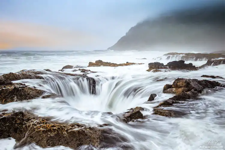 The Oregon coast long exposure of a blowhole with sea water dripping from rocks.