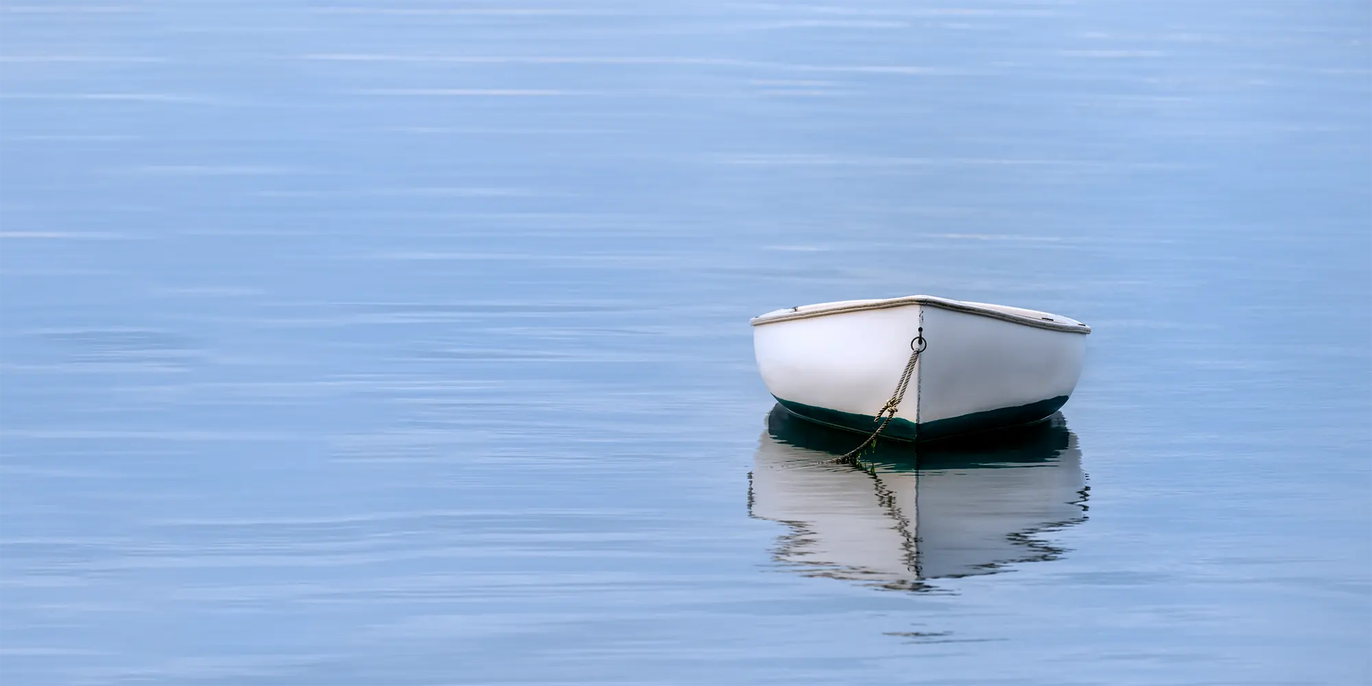 Row boat reflected on calm water