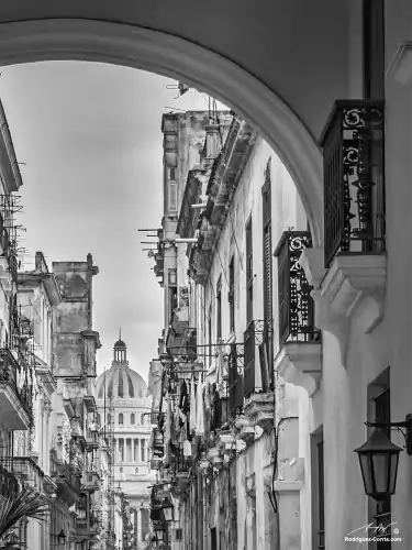 A black and white view of the Havana capitol building from Old Havana showing typical colonial architectural details.